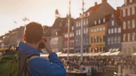 Ein Tourist fotografiert eine bekannte Straße in Nyhavn, Kopenhagen