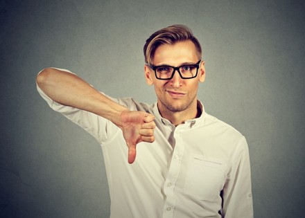 Mann hält Daumen nach unten