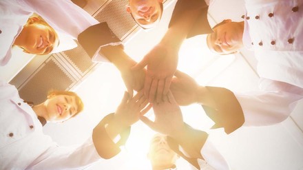 Team streckt zur Motivation die Hände in die Mitte