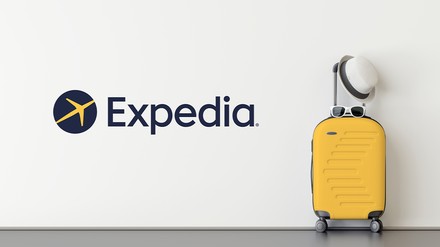 Expedia Logo und ein gelber Rollkoffer