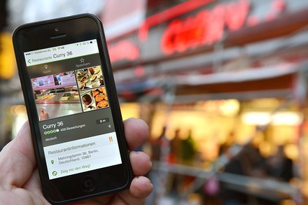 Ein Mann mit einem Handy vor einem Restaurant