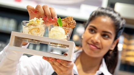 Eine Frau hält zwei Eisbecher in der Hand