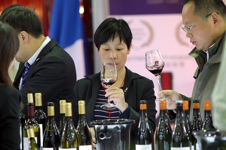 Asiatische Messebesucher bei einer Weinverkostung