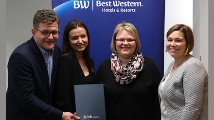 Vier Menschen freuen sich über die Vertragsunterzeichnung der Best Western Hotel Group und der IUBH