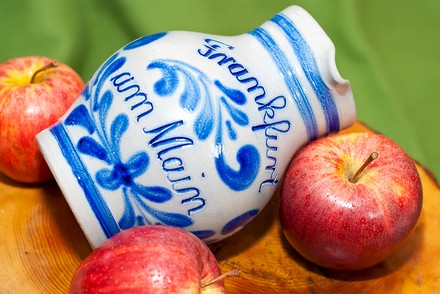 Ein Krug mit Apfelwein und mehrere rote Äpfel