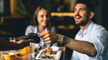 Bargeldloses Bezahlen wird immer beliebter. Dies stellt jedoch eine Herausforderung für Gastronomen dar. (Foto: © cherryandbees/stock.adobe.com)
man paying bill at fancy restaurant