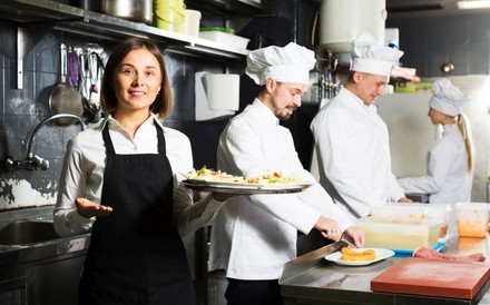 3 Köche und eine Kellnerin bei der Arbeit