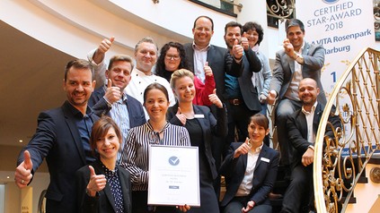 Zahlreiche Vertreter des VILA VITA HOtels auf einer Treppe sitzend