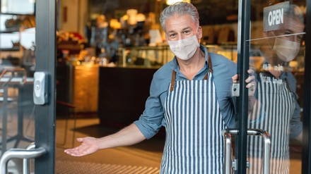 Wirt bittet Leute mit Geste einzutreten