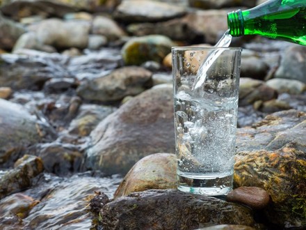 Mineralwasser wird in Glas geschüttet