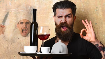 Mann mit Bart hält verschiedene Getränke auf Tablett