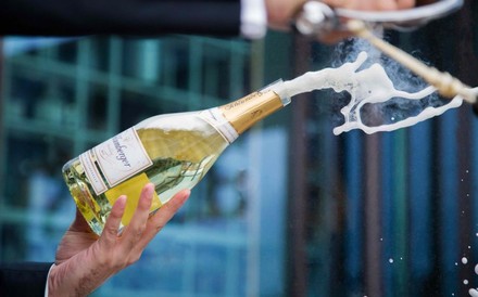 Eine Flasche Sekt wird mit einem Säbel sabriert