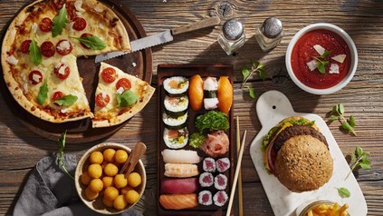 Pizza, Sushi, Burger auf Tisch