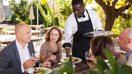 Servicekraft bedient Tisch auf der Terrasse