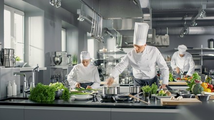 Wird in der Gemeinschaftsverpflegung veganes Essen angeboten, wählen Gäste diese auch. (Foto: © Gorodenkoff/stock.adobe.com)
Köche bereiten in der Großküche Essen mit viel Gemüse zu