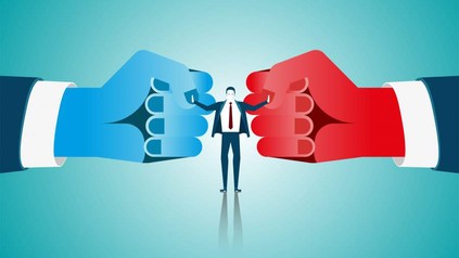 Mann in Anzug steht zwischen zwei riesigen Fäusten