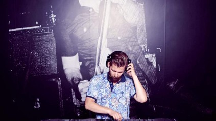 DJ mit Schnurrbart an Turntables