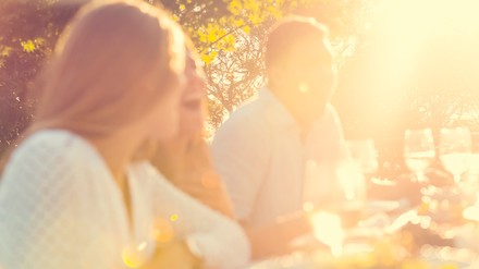 Freunde sitzen zusammen, lachen und essen.