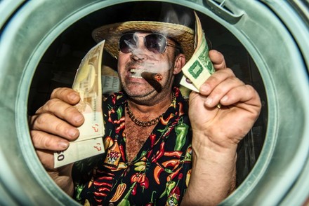 Mann mit Strohhut, Sonnenbrille und Zigarre hält Geldscheine in den Händen