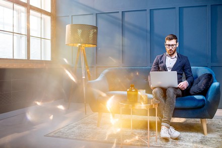 Ein Mann mit einem Laptop in einem Hotelzimmer