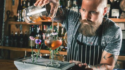 Barkeeper mixt Getränk in moderner Bar