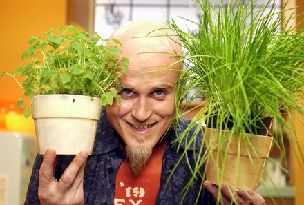 Koch Ralf Zacherl mit zwei Kräutertöpfen in den Händen