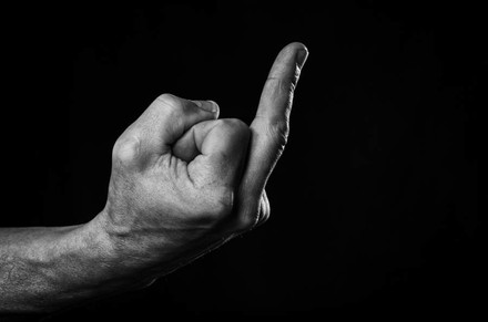 Eine Hand erhebt den Mittelfinger