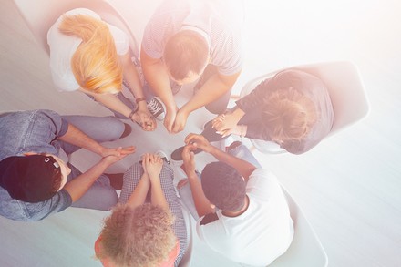 Eine Handvoll junger Menschen sitzt im Kreis und diskutiert