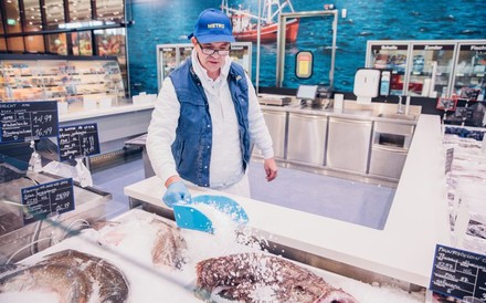 Metro-Verkäufer schüttet Eis in die Fisch-Theke
