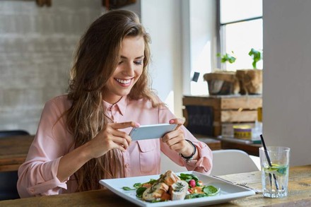 Frau macht Foodporn Bild mit Smartphone