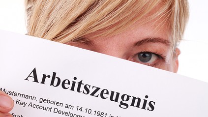 Eine Frau mit einem Arbeitszeugnis in der Hand