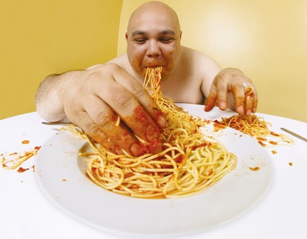 Dicker Mann isst Spaghetti mit bloßen Händen