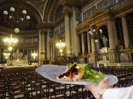 Die Pariser Kirche Madeleine komplett bestuhlt und ein Kellner, der ein Gericht serviert
