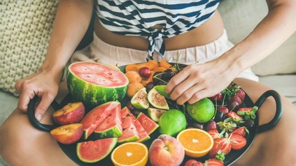 Frau hält Teller mit Obst