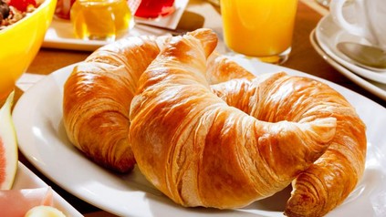 Croissants auf Teller mit Orangensaft