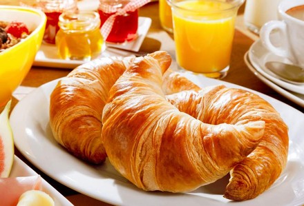 Croissants auf Teller mit Orangensaft
