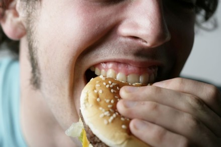 Mann beißt in Burger