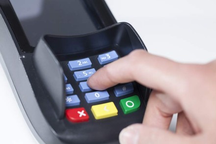 Person tippt PIN Code in EC-Karten Lesegerät