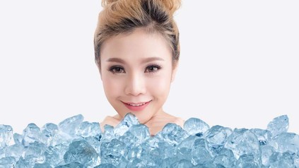 Eine Chinesin vor einem Stapel Eiswürfel