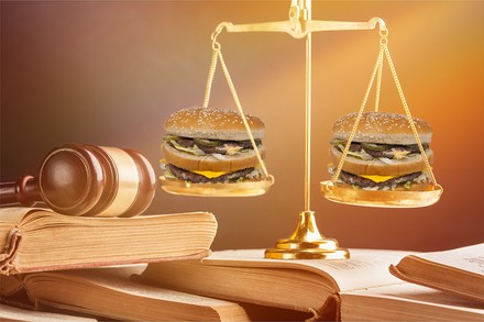 Eine richterliche Waagschale, in der sich zwei Big Macs befinden