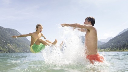 Zwei Kinder spielen im See