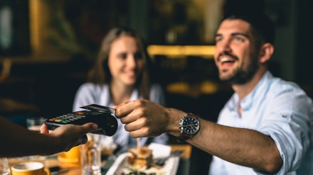 Mann bezahlt Rechnung im Restaurant