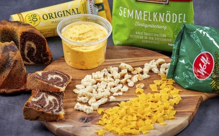 Diverse Fertigprodukte, wie Semmelknödel Fertigmischung, Mayonnaise, Senf, Kuchenmischungen und Nudeln auf einem Holzbrett