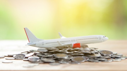 Ein Modell eines Flugzeugs und ein Stapel Geldmünzen