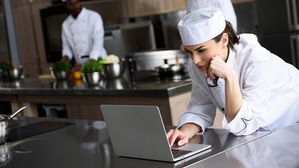 Eine Köchin mit einem Laptop