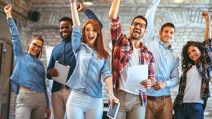 Eine Gruppe junger Leute streckt siegessicher die Arme in die Höhe