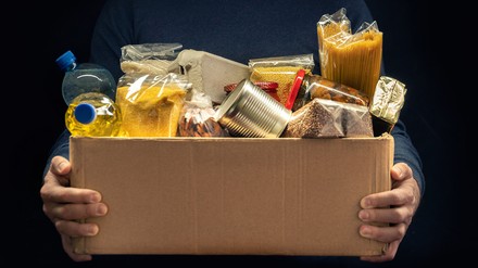 Die Deutsche Bahn spendet ihre nicht verbrauchten frischen Lebensmittel aus der Bordgastronomie an unterschiedliche Organisationen und Initiativen (Symbolbild). (Foto: ©Andrii/stock.adobe.com)
Ein Mann hält eine Box mit Lebensmitteln in den Händen vor einem schwarzen Hintergrund