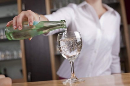 Wirtin gießt Wasser in Glas