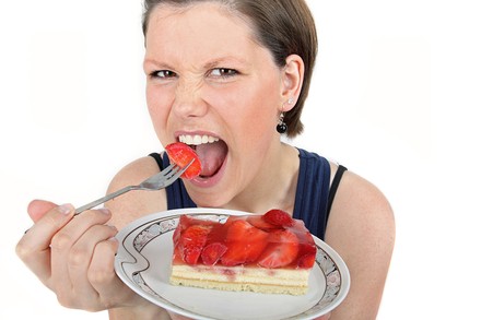 Frau verspeist Erdbeerkuchen