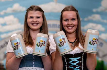 Zwei Frauen halten je zwei Bierkrüge in Händen